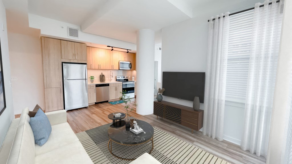A modern living room with a white sofa and a television.at Makers Rise, Herndon