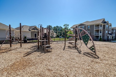A playground with a slide and swings in a residential area.