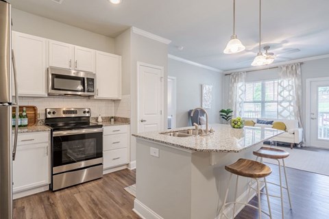 A kitchen with white cabinets and a stainless steel refrigerator.