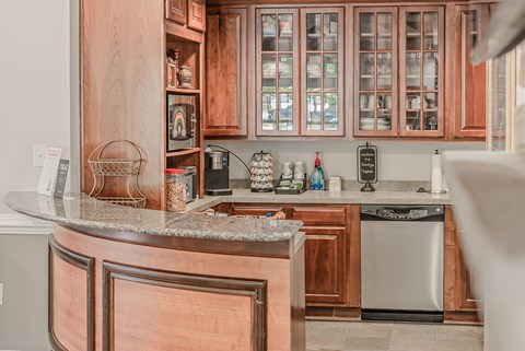A kitchen with wooden cabinets and a granite counter.