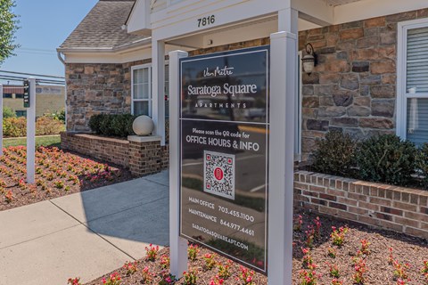 A sign for Saratoga Square Apartments is displayed in front of a building.