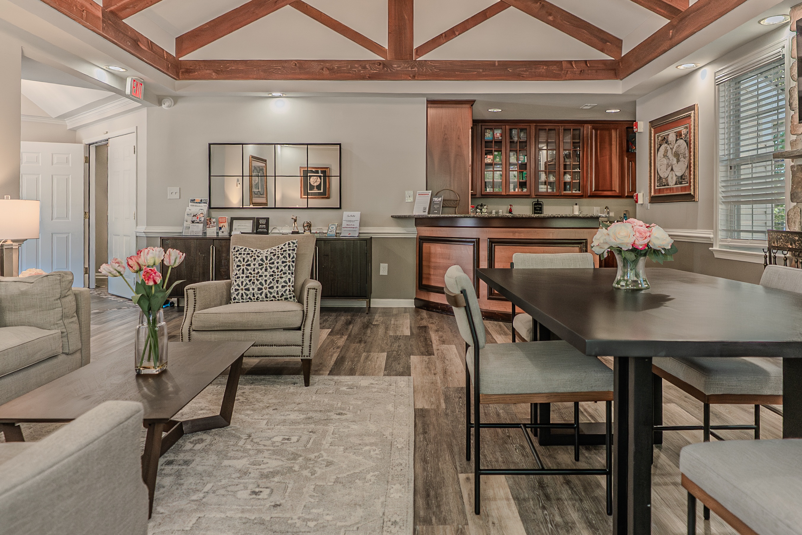 A well-lit, spacious kitchen and living room with a dining table and chairs.