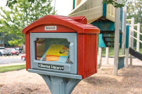 community library small red box with a glass window and a grey base.