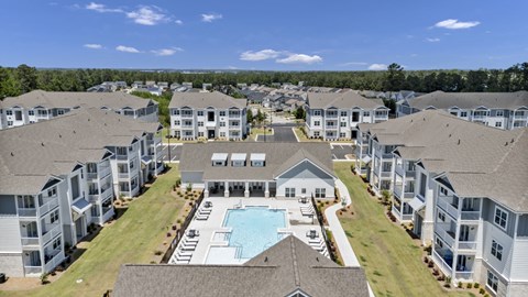 A large apartment complex with a swimming pool in the center.