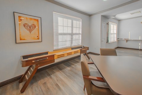 A dining room with a wooden table and chairs.