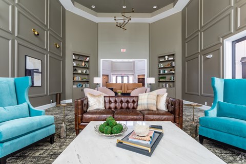 A living room with a white coffee table and a brown couch.