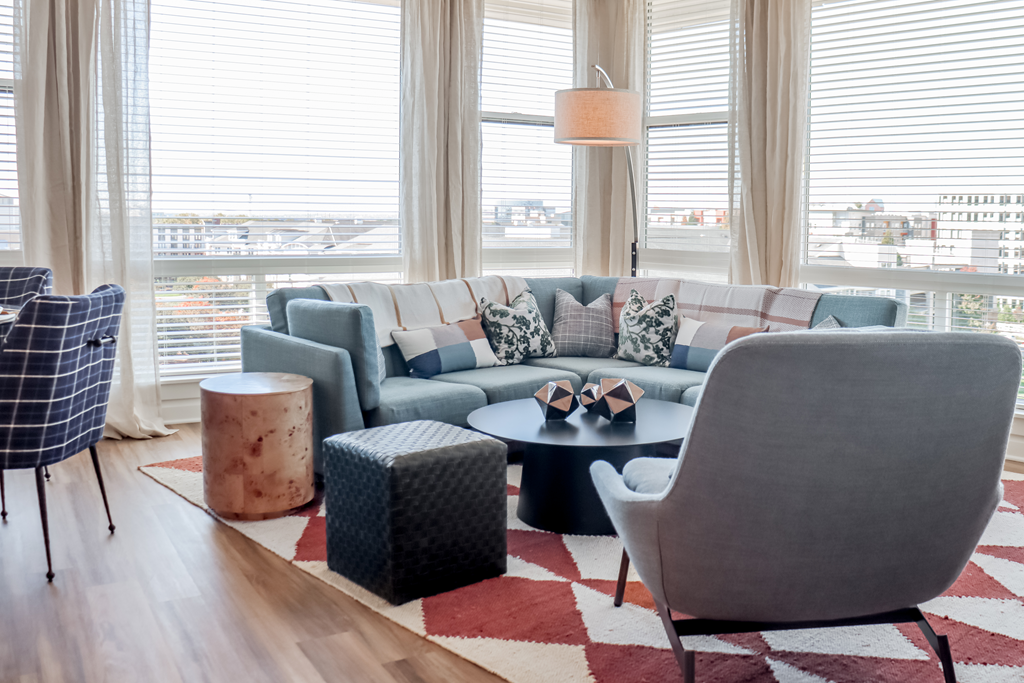 a living room with couches and chairs and a rug at Makers Rise, Herndon, VA 20171