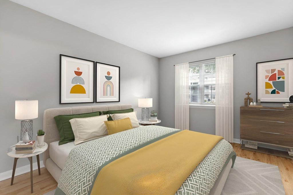 a bedroom with a bed and pictures on the wall at West Pointe Apartments in Burlington, NC