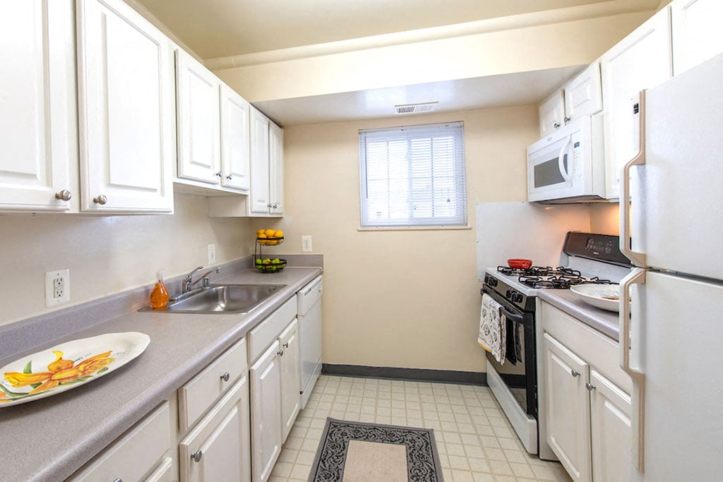 a kitchen with white cabinets and appliances and a sink