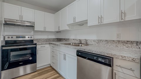 A modern kitchen with stainless steel appliances and white cabinets.