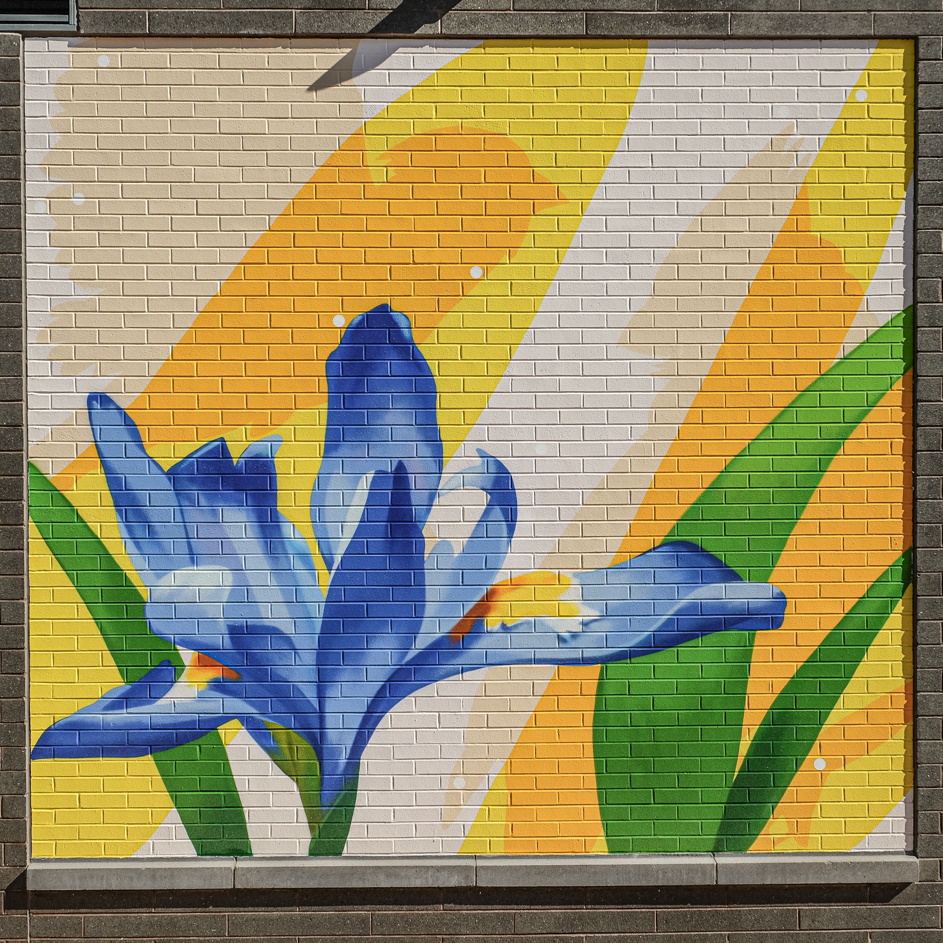 a mosaic of a flower on a brick wall