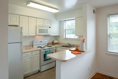 A kitchen with white cabinets and appliances.