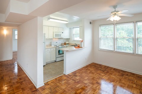 A kitchen with white cabinets and a wooden floor.
