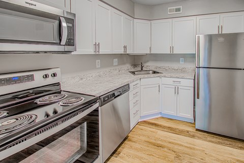 A kitchen with a stove, oven, microwave, and refrigerator.