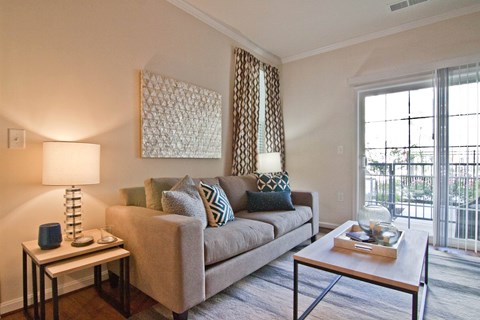 A living room with a couch, a table, and a lamp.