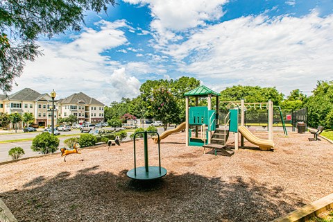 A playground with a green slide and a yellow slide.