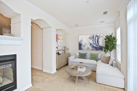 A living room with a fireplace and a painting on the wall.