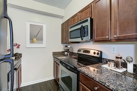 A kitchen with a black microwave above a stove.