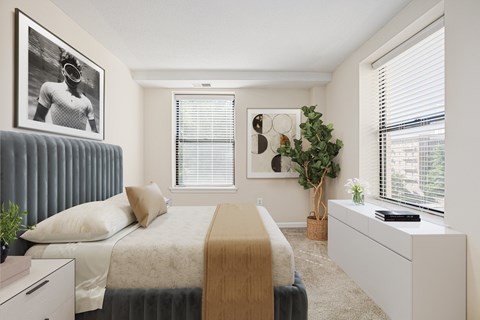 A bedroom with a bed, a dresser, and a window with blinds.