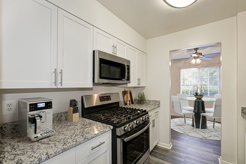 A kitchen with a black stove top oven and a microwave above it.