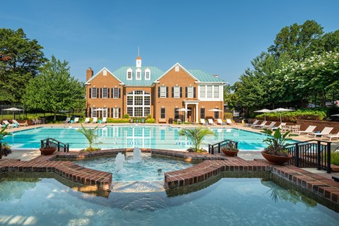 A large building with a pool in front of it.