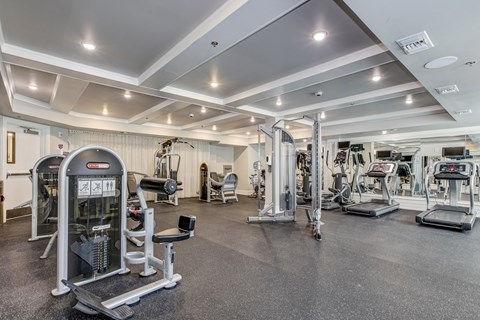 A gym with a variety of equipment including treadmills, weights, and exercise machines. at Kensington Place Apartments, Woodbridge, Virginia