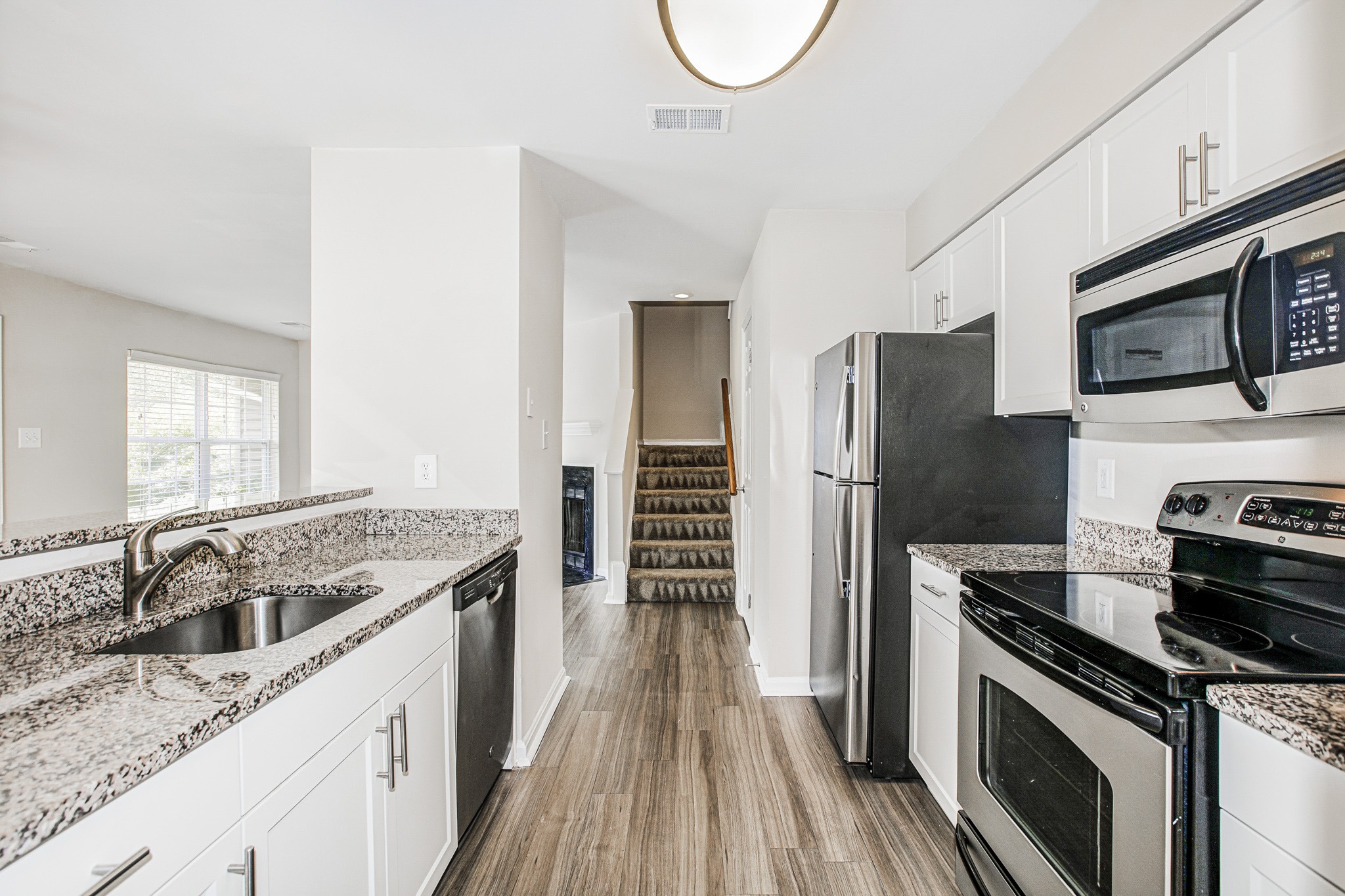 A kitchen with black appliances and white cabinets.