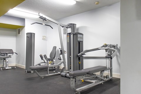 A gym with a weight machine and a bench.