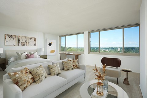 A living room with a white couch and a glass table.