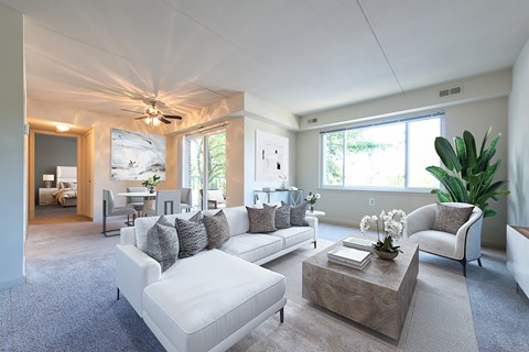 A living room with a white couch and a wooden coffee table.