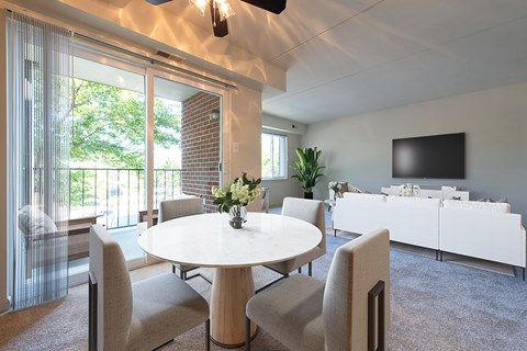 A modern dining room with a white table and chairs.