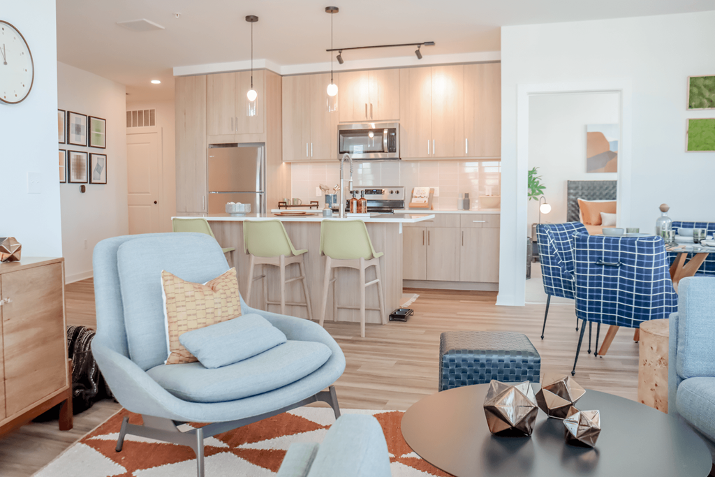 a living room and kitchen with blue chairs and a table at Makers Rise, Herndon, VA