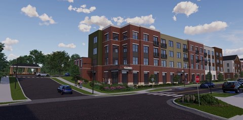 A modern apartment complex with a red brick exterior and a green roof.
