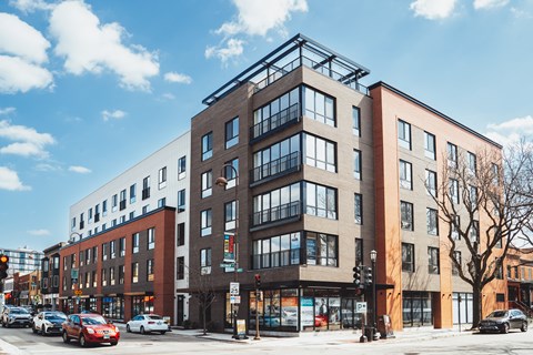 A modern multi-story building with a mix of brick and glass facades.
