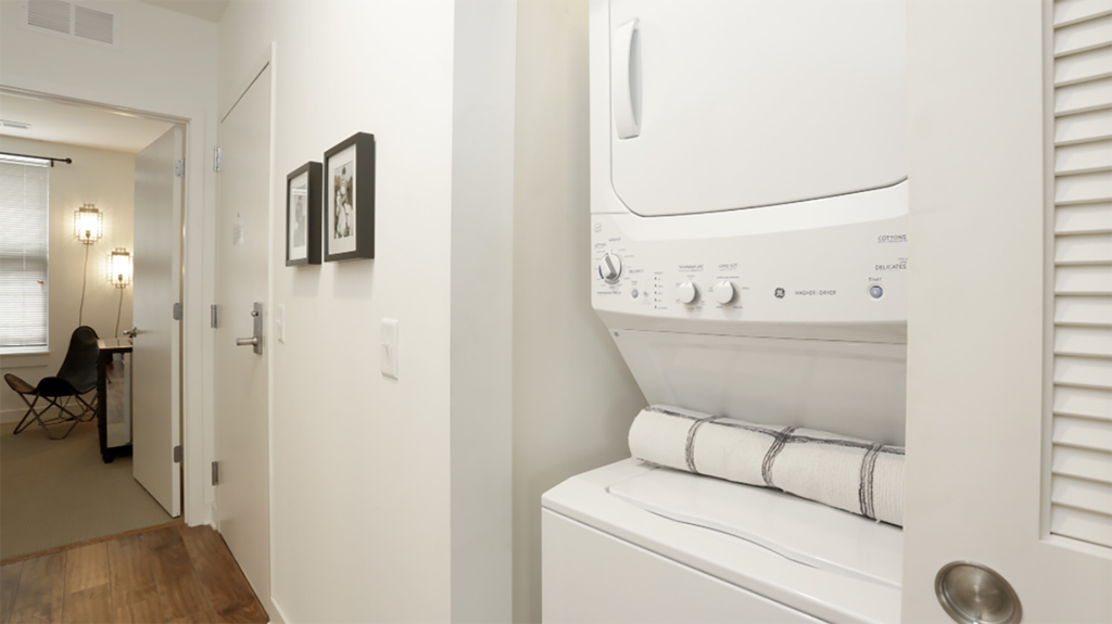 a white washer and dryer in a room with a hallway and a door
