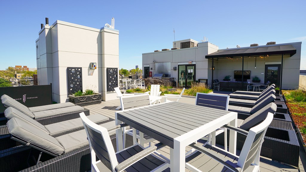 a patio with a table and chairs and a building in the background