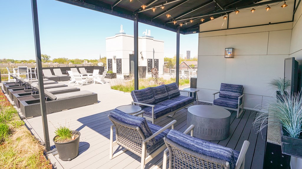 a patio with blue chairs and tables and a roof