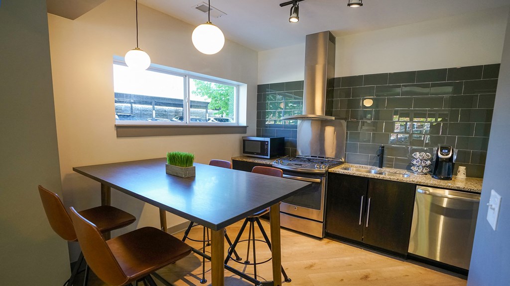 a kitchen with a dining table and a stove and a window