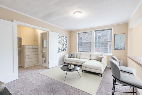 A living room with a white couch and a grey chair.
