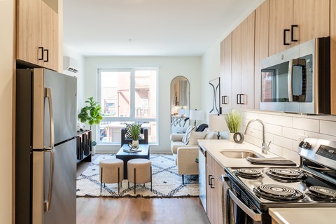 A modern kitchen with a refrigerator, stove, and sink.