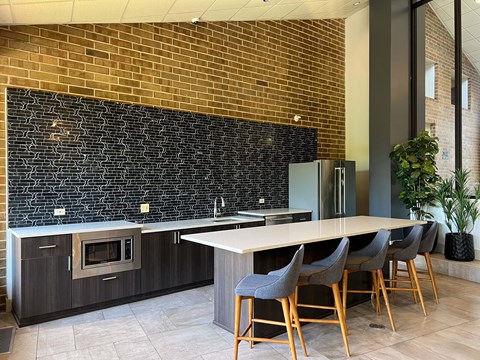 A kitchen with a long table and chairs.