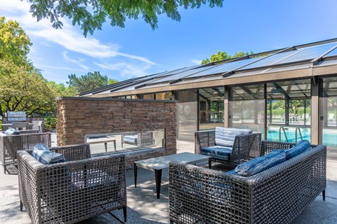 A patio with a table and chairs and a pool in the background.