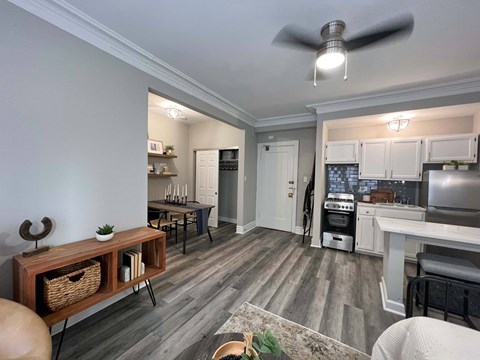 A kitchen with a white counter and a white ceiling fan.