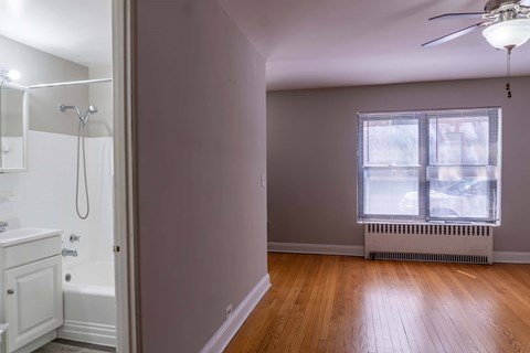 A room with a window and a ceiling fan.