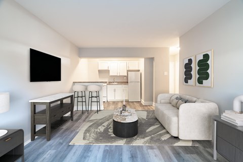 A modern living room with a white couch and a television on the wall.