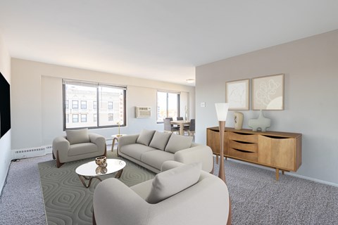 A living room with a grey carpet and white walls.