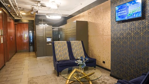 A room with a blue chair and a television screen showing a resident program.