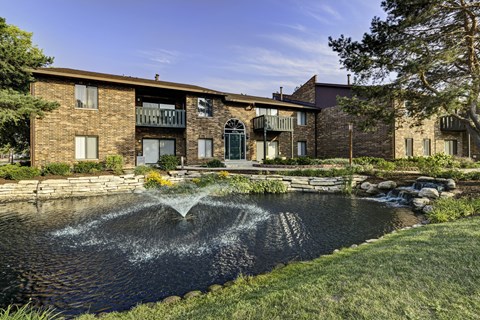 A building with a water feature in front.