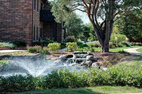 A waterfall in a garden sprays water into the air.