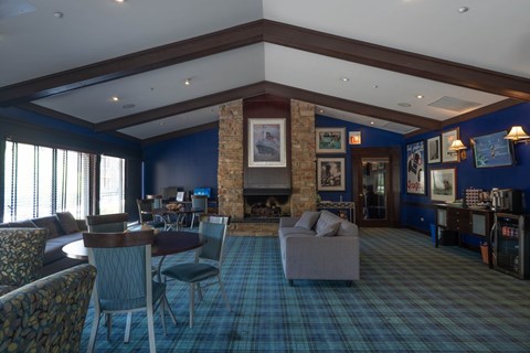 A living room with a fireplace and a blue carpet.